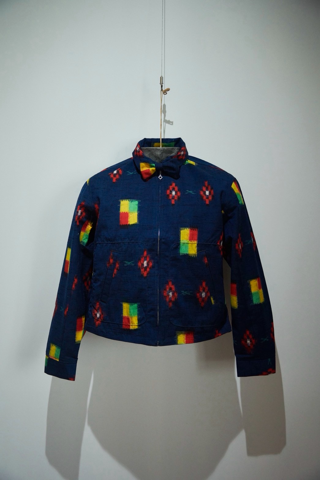 紺絣に原色の絣紋のシャツジャケットと蝶ネクタイ